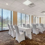 meeting space with rows of white tables and chairs